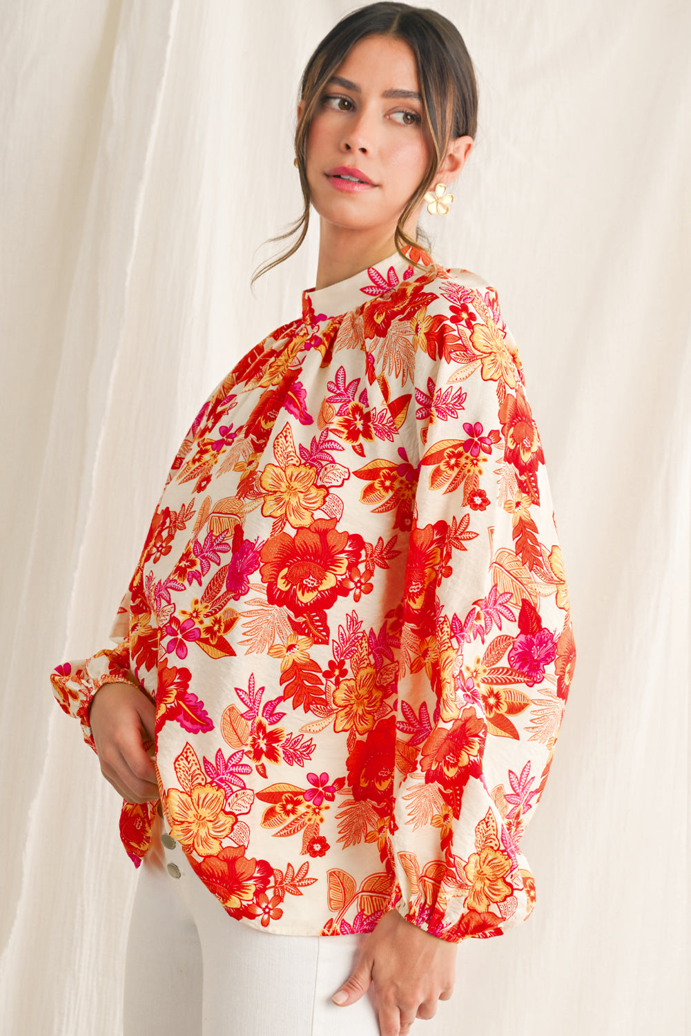 Woman wearing a colorful floral blouse against a white background