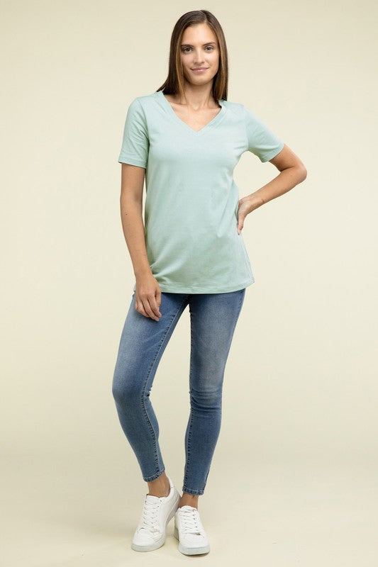 Woman wearing a light blue t-shirt and blue jeans on a beige background