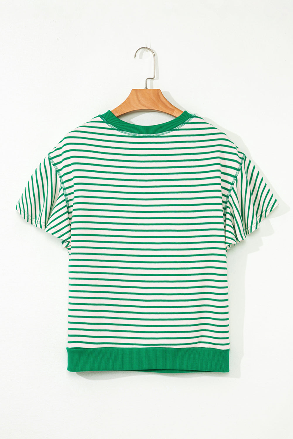 Green and white striped t-shirt on a wooden hanger against a white background