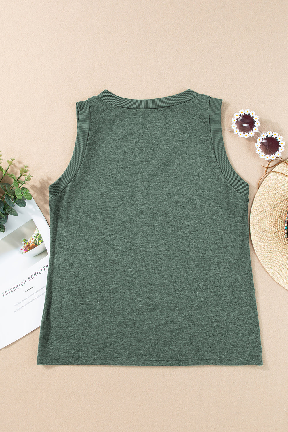 Green tank top on a beige surface with decorative items