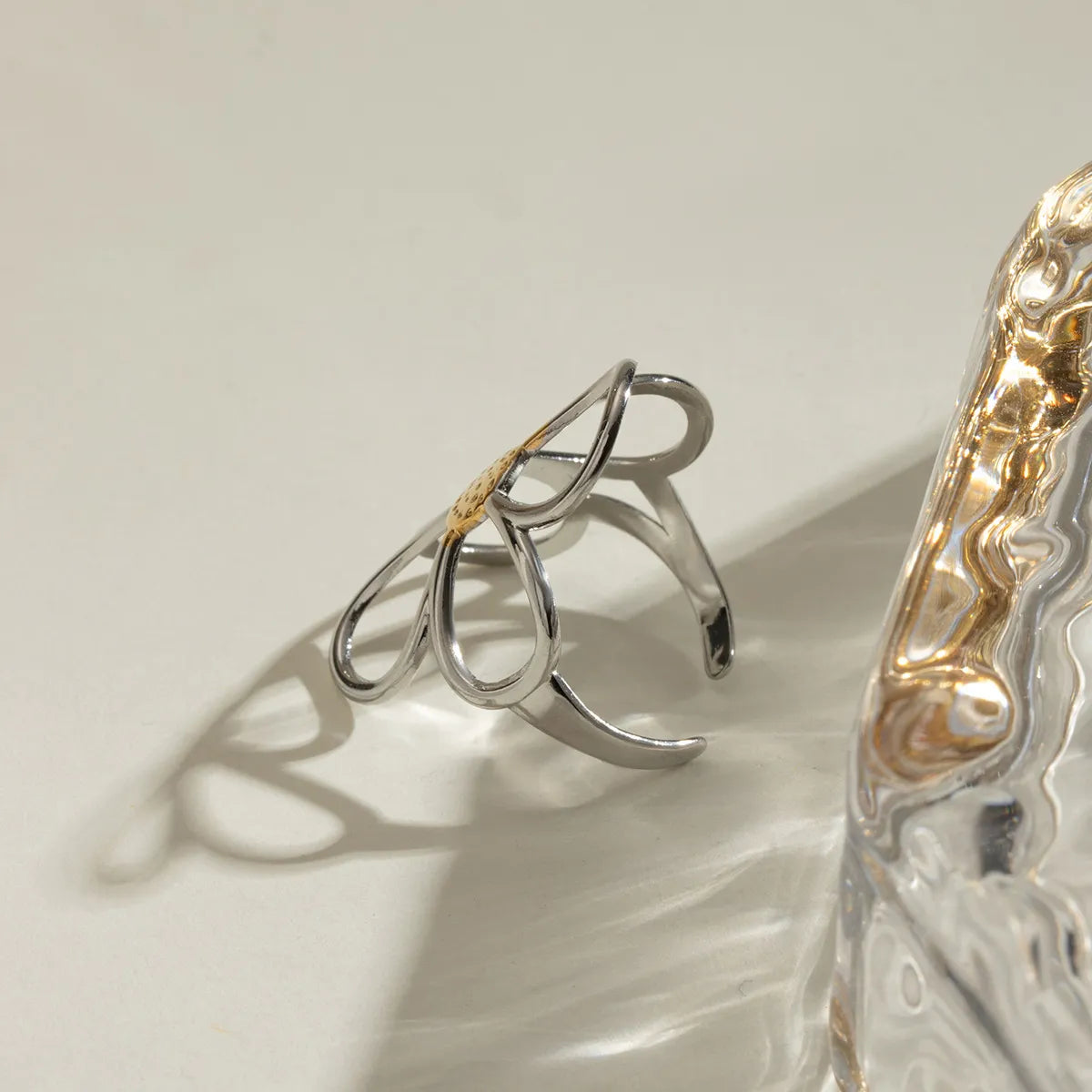 Silver ring with a gold accent on a light beige background