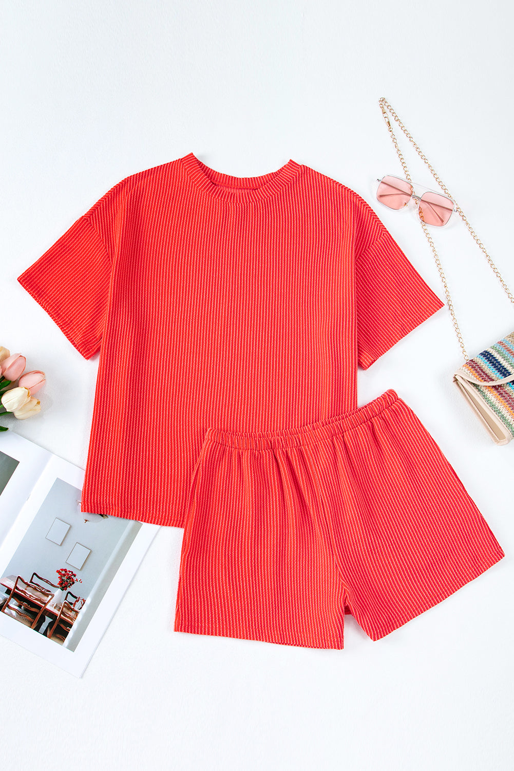 Red ribbed top and shorts set on a white background with decorative items.