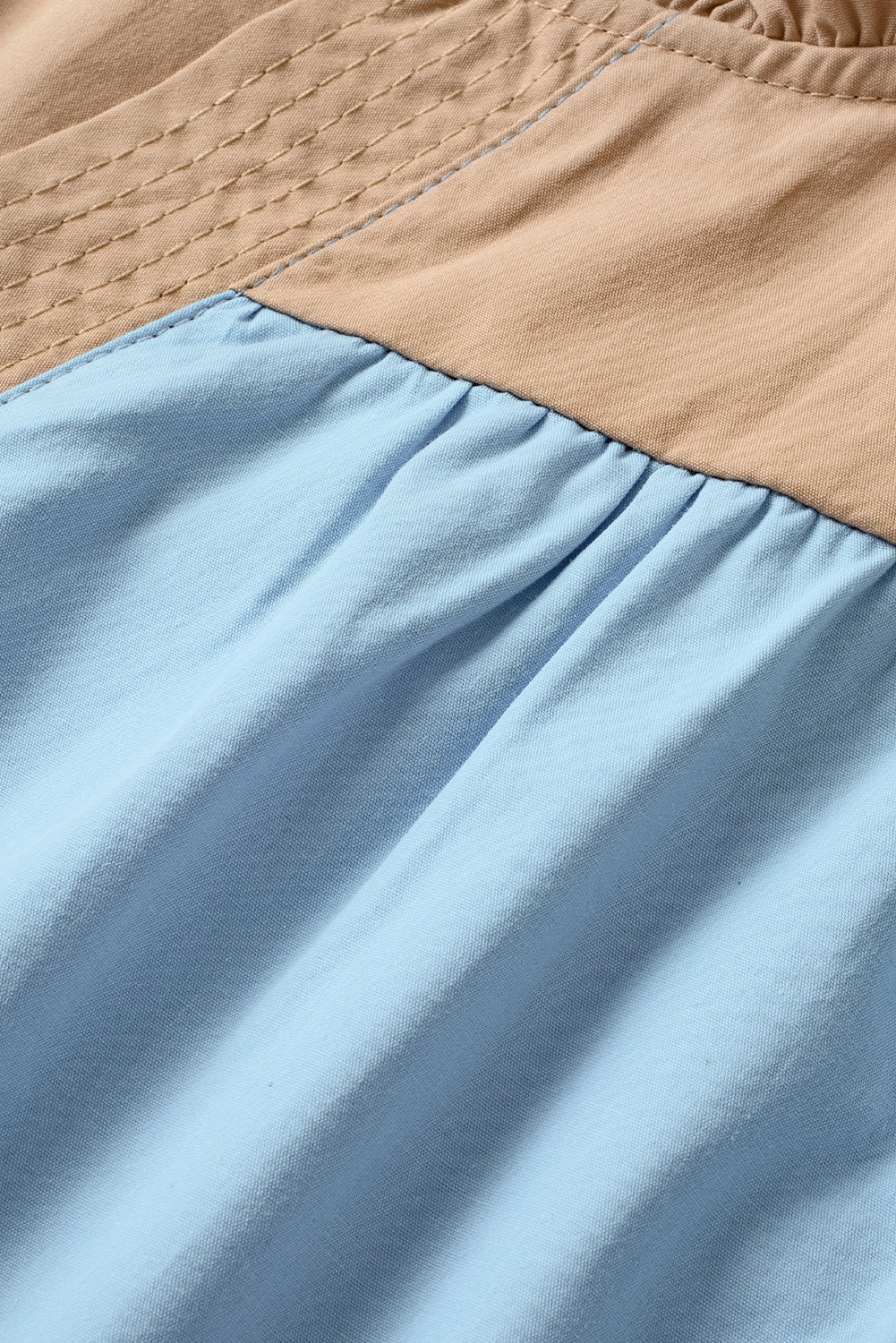 Close-up of a blue fabric with a beige top section.