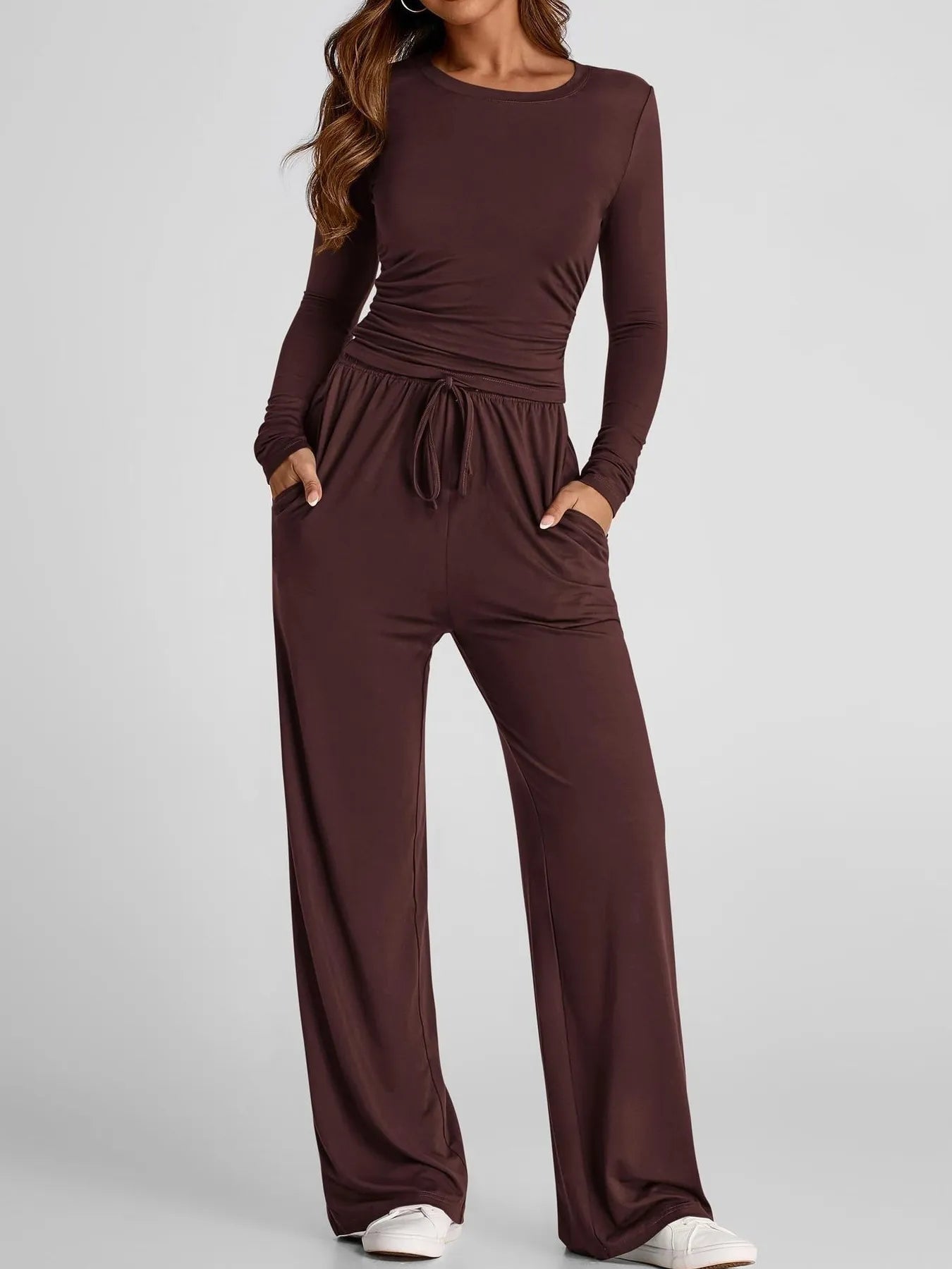 Brown jumpsuit worn by a model on a light gray background