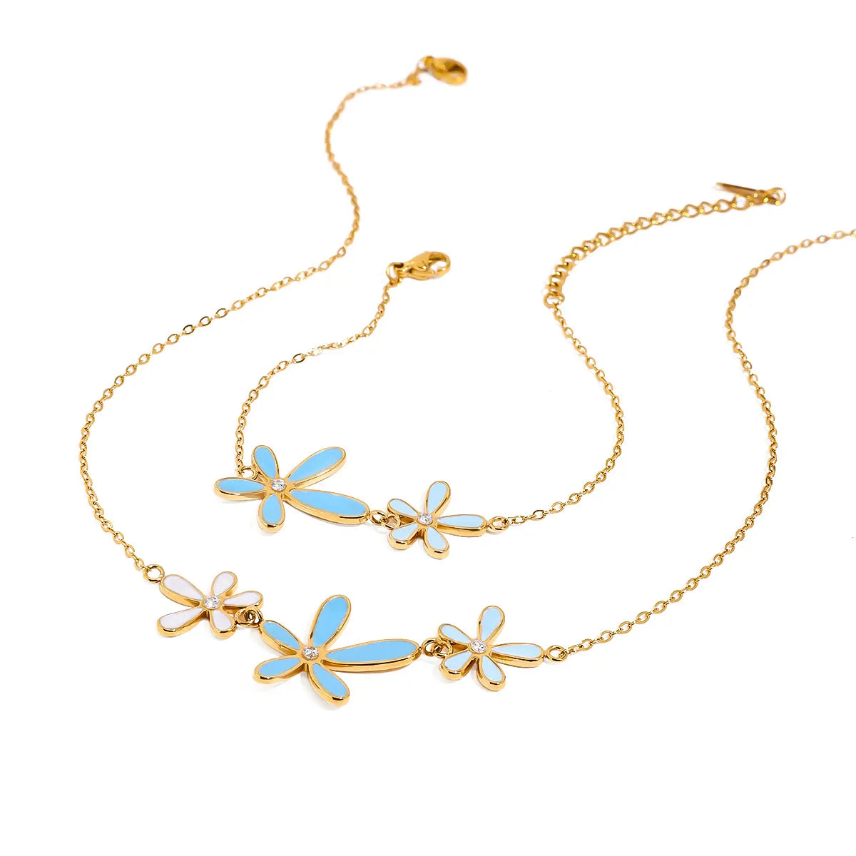 Gold necklace with blue flower pendants on a white background