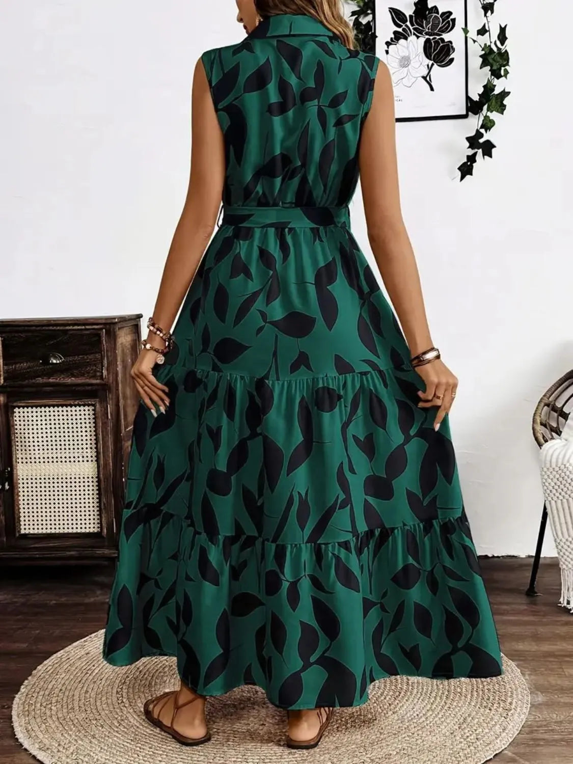 Woman wearing a green dress with black leaf pattern indoors.