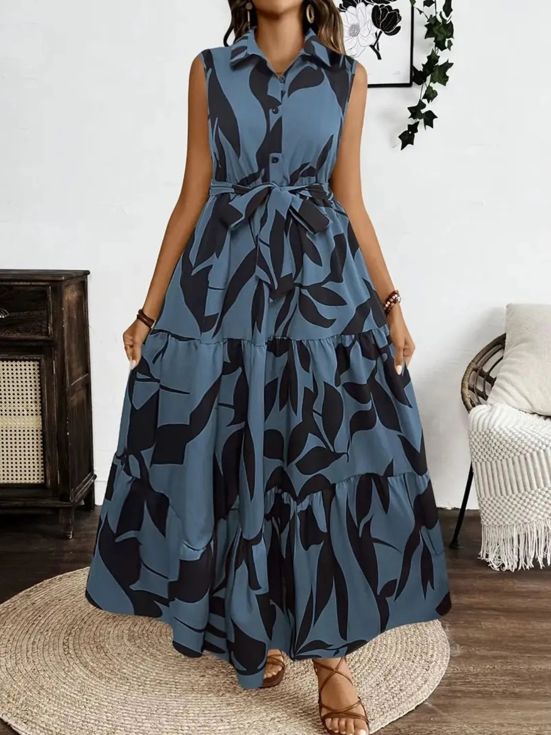 Woman wearing a blue and black patterned dress in a room with a fireplace and chair.