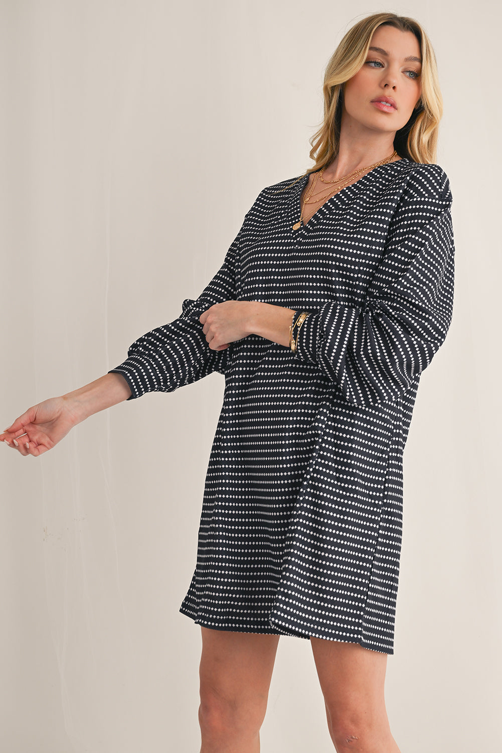 Woman wearing a black and white patterned dress on a beige background