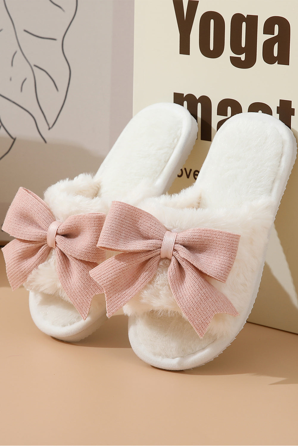 White slippers with pink bows on a beige surface