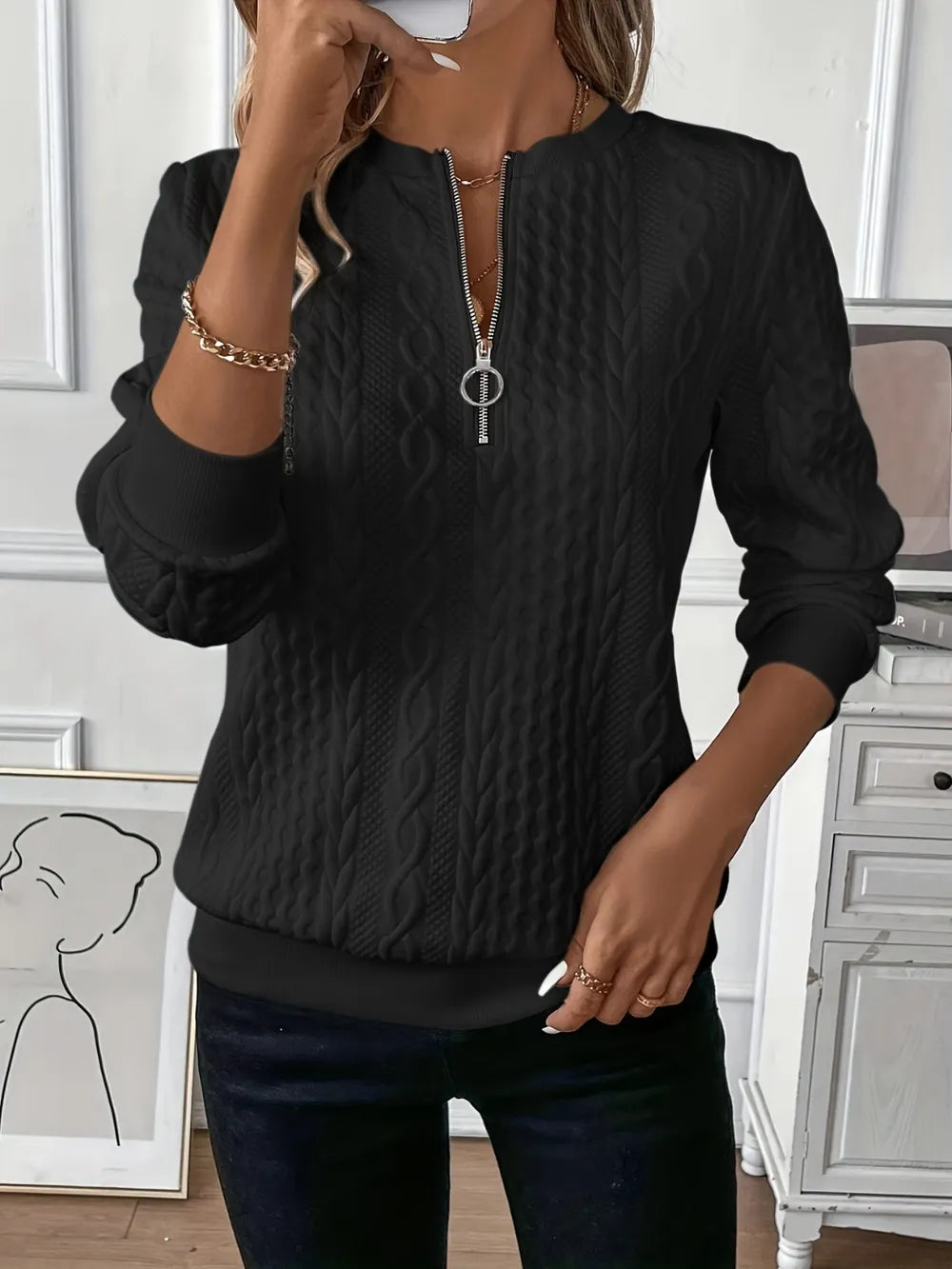 Person wearing a black textured sweater in an indoor setting