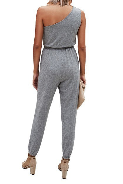 Gray one-shoulder jumpsuit worn by a person on a white background