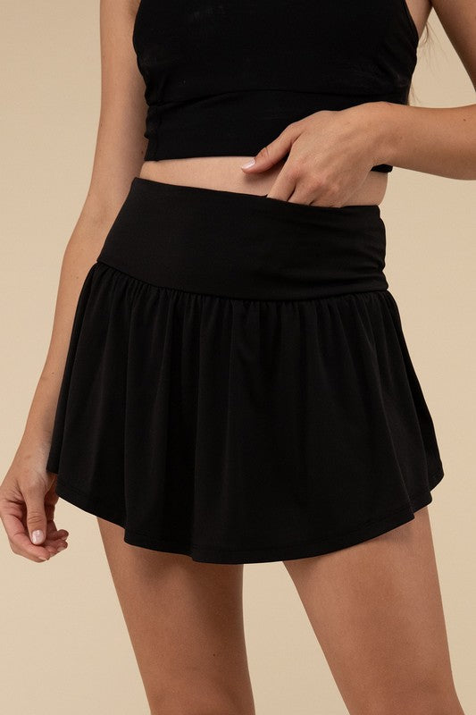 Black skirt worn by a person on a beige background