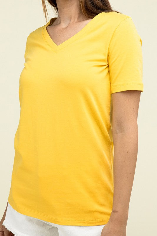 Yellow t-shirt worn by a person on a beige background