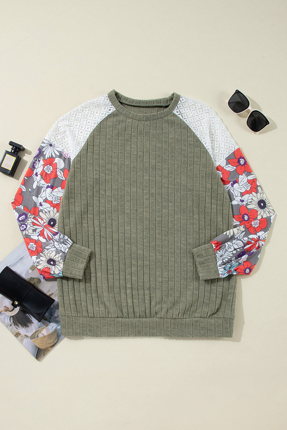 Green sweater with floral sleeves on a beige background