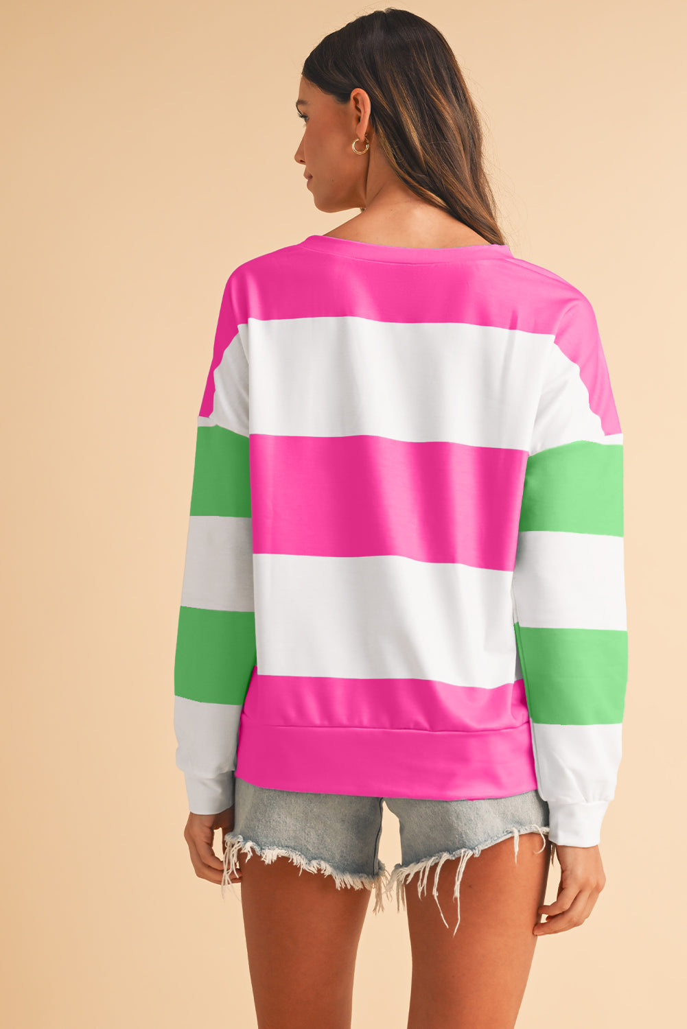 Person wearing a colorful striped sweater on a beige background