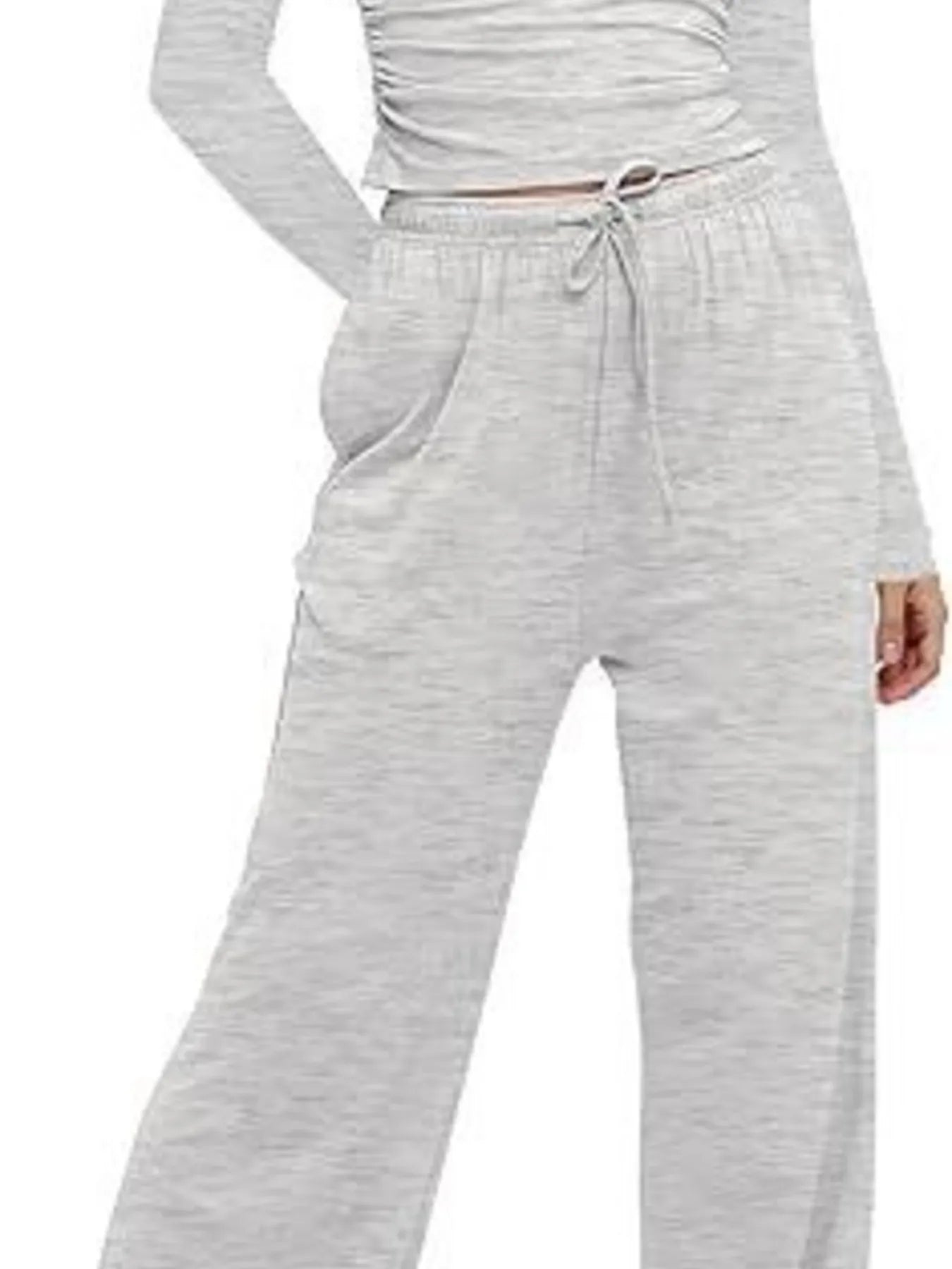 Gray sweatpants worn by a person on a white background