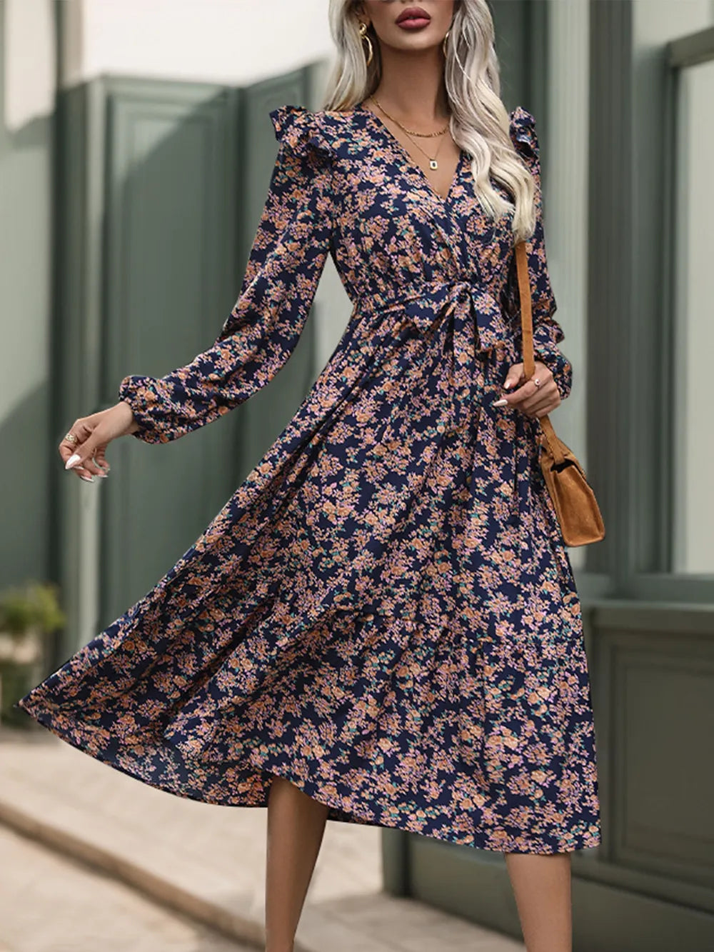 Woman wearing a floral dress with long sleeves, standing outdoors.