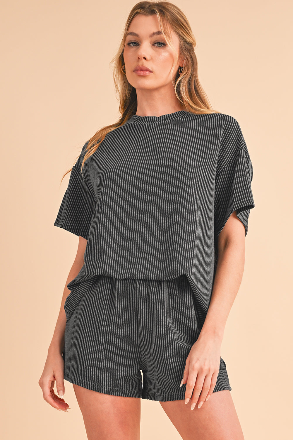 Woman wearing a black and white striped outfit on a beige background