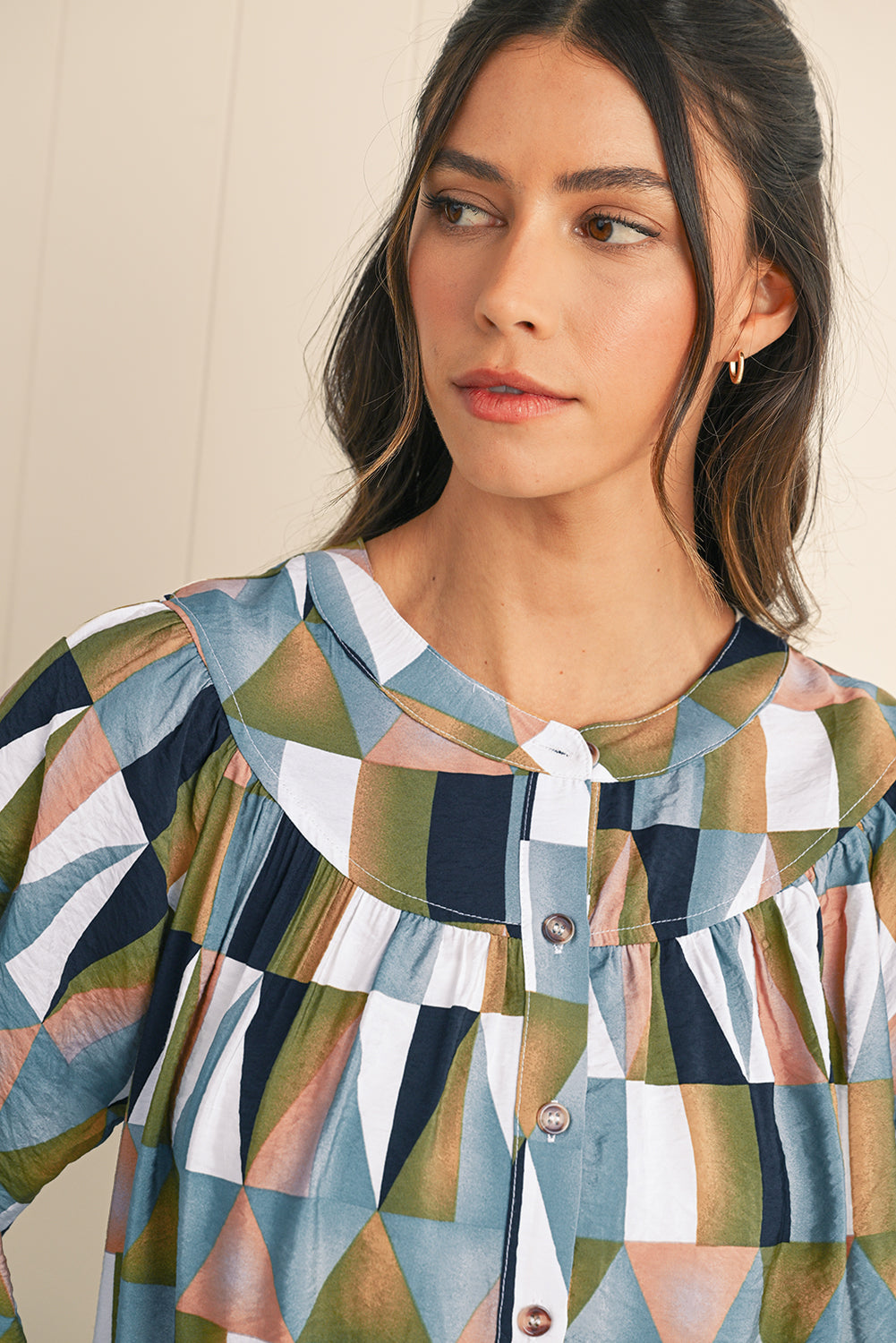 Woman wearing a geometric patterned dress with a neutral background