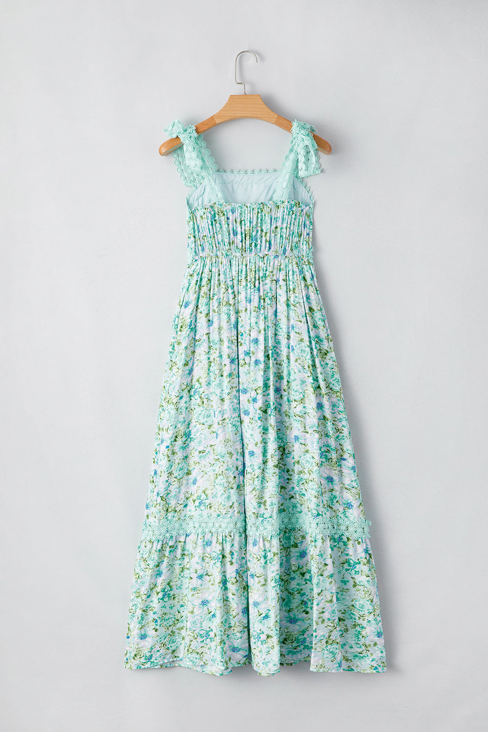 Floral dress on a hanger against a gray background