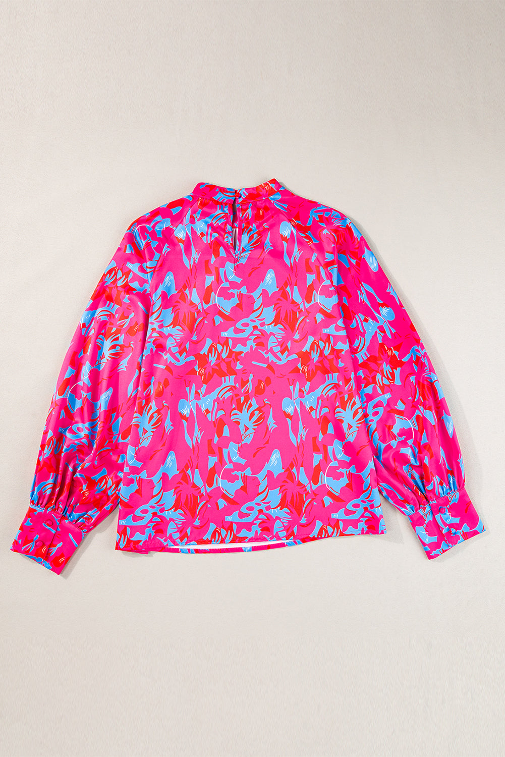 Pink and blue patterned long-sleeve shirt on a beige background