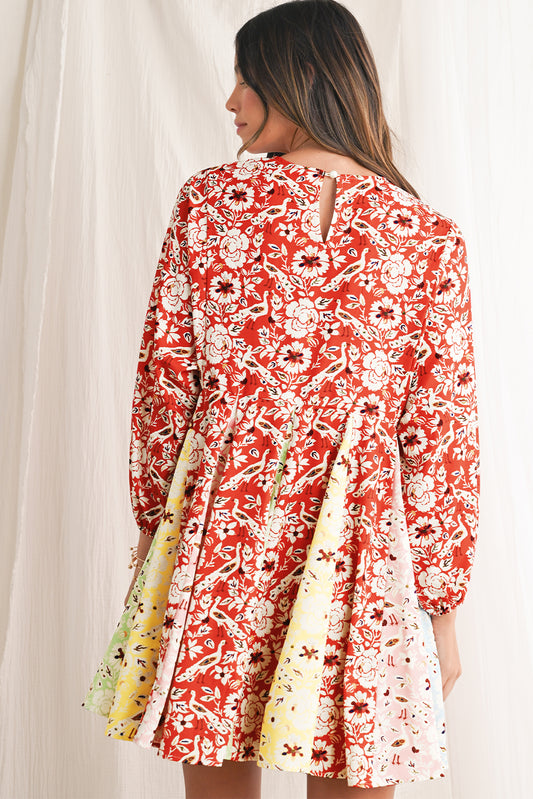 Woman wearing a red floral dress with long sleeves against a white background