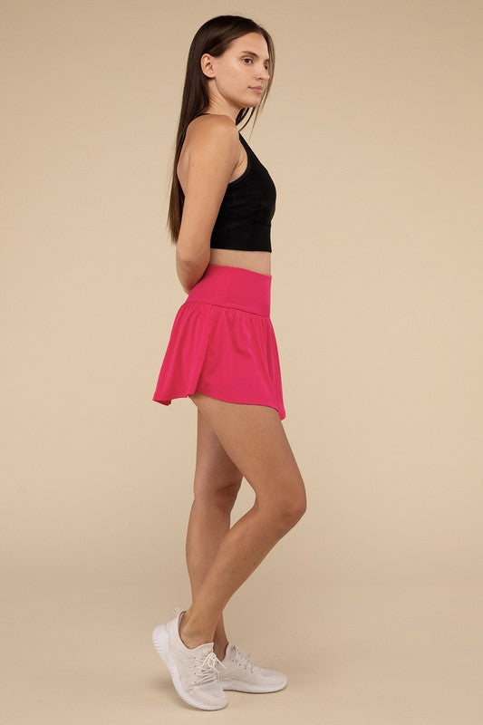Woman wearing a black top and pink skirt on a beige background