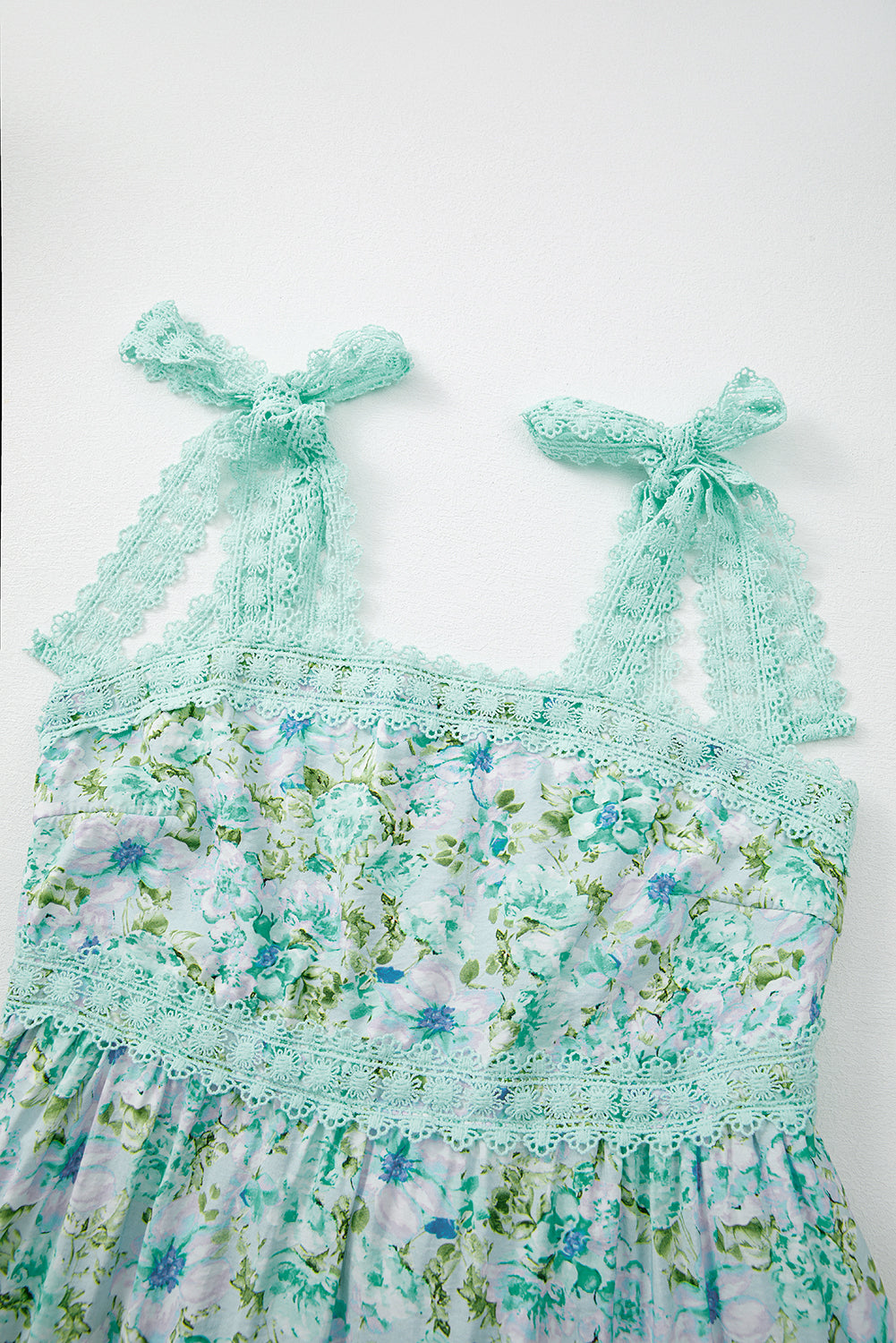 Mint green floral dress with bow straps on a white background