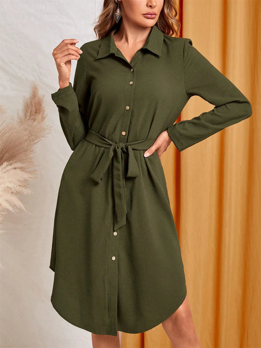 Green dress with a belt worn by a model against a neutral background