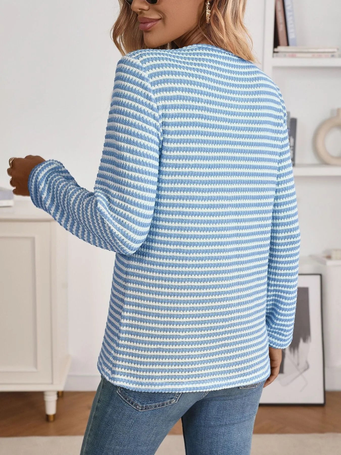 person wearing a long sleeve striped blouse