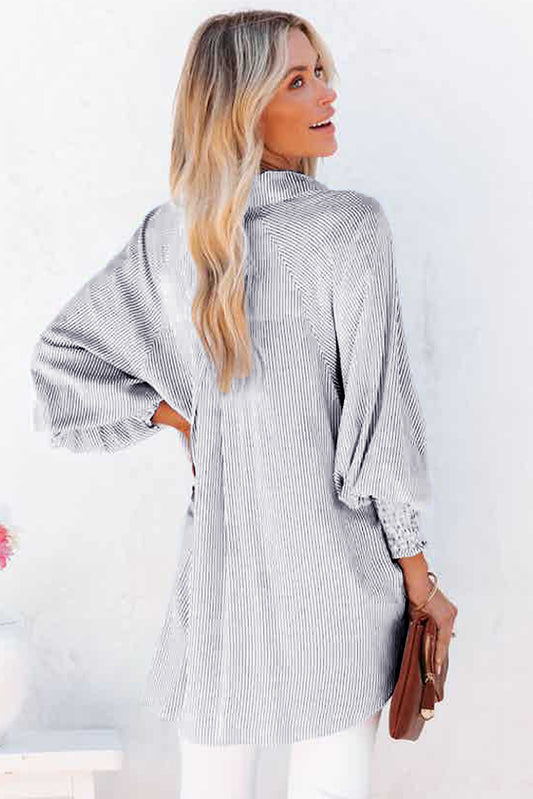 Woman wearing a gray and white striped dress with a plain background