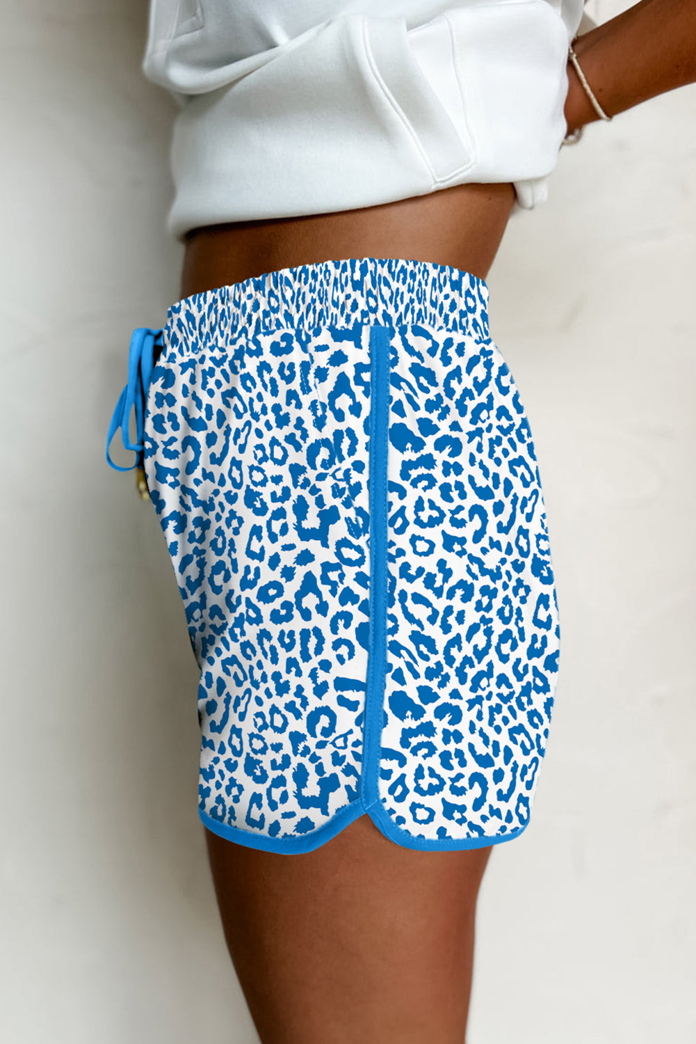 Blue leopard print shorts worn by a person on a plain background
