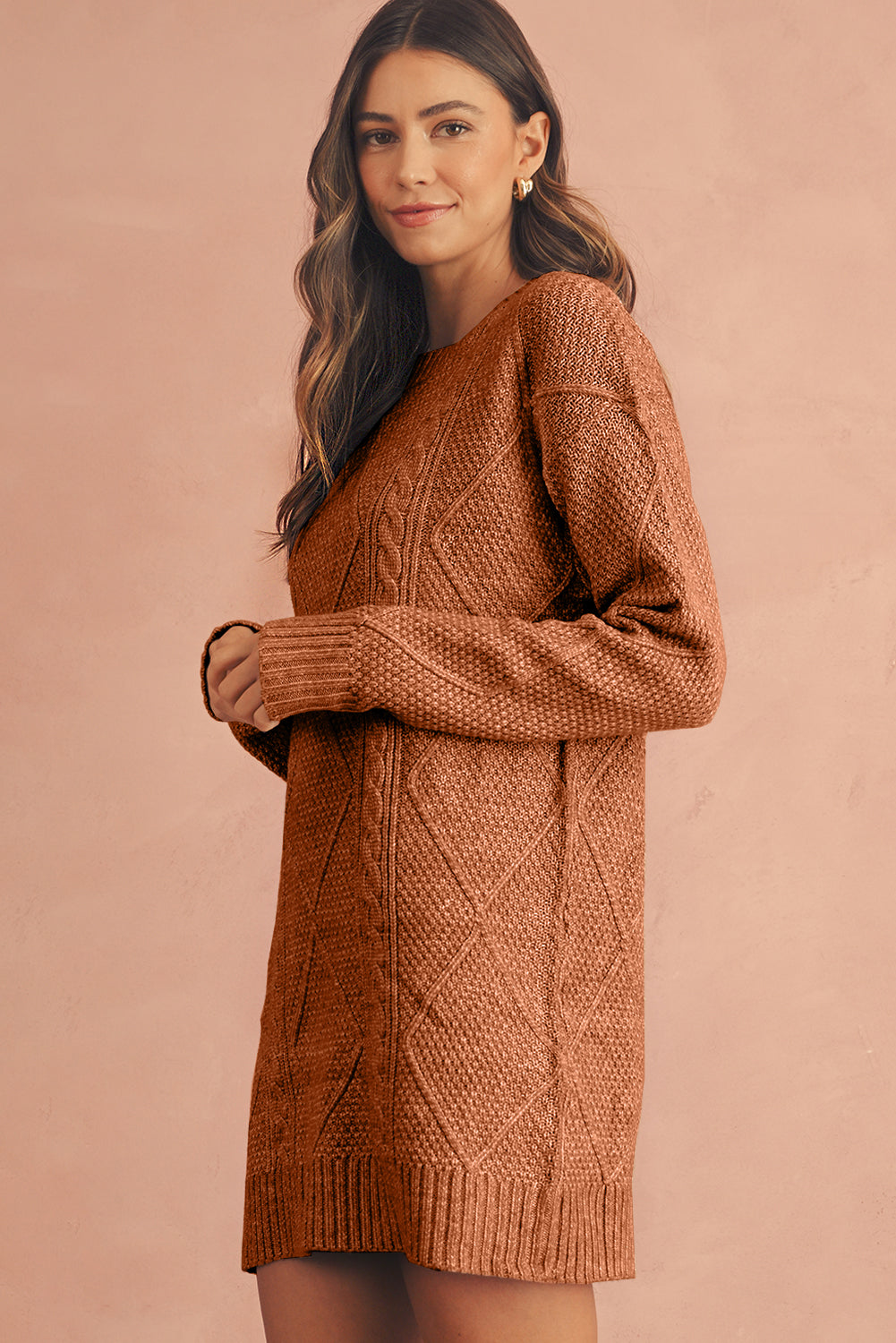 Woman wearing a brown knitted dress against a beige background