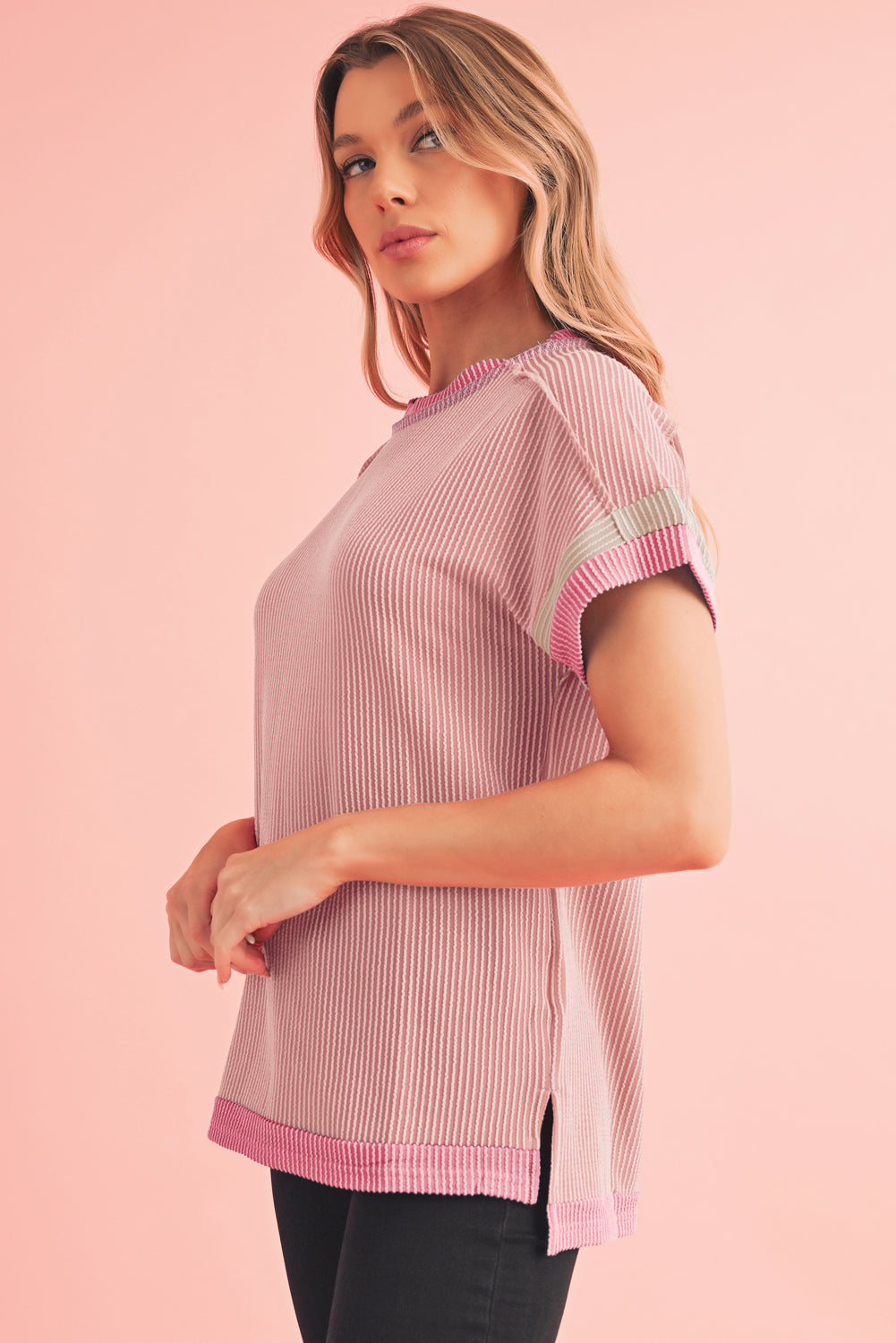 Woman wearing a pink and white striped shirt against a pink background