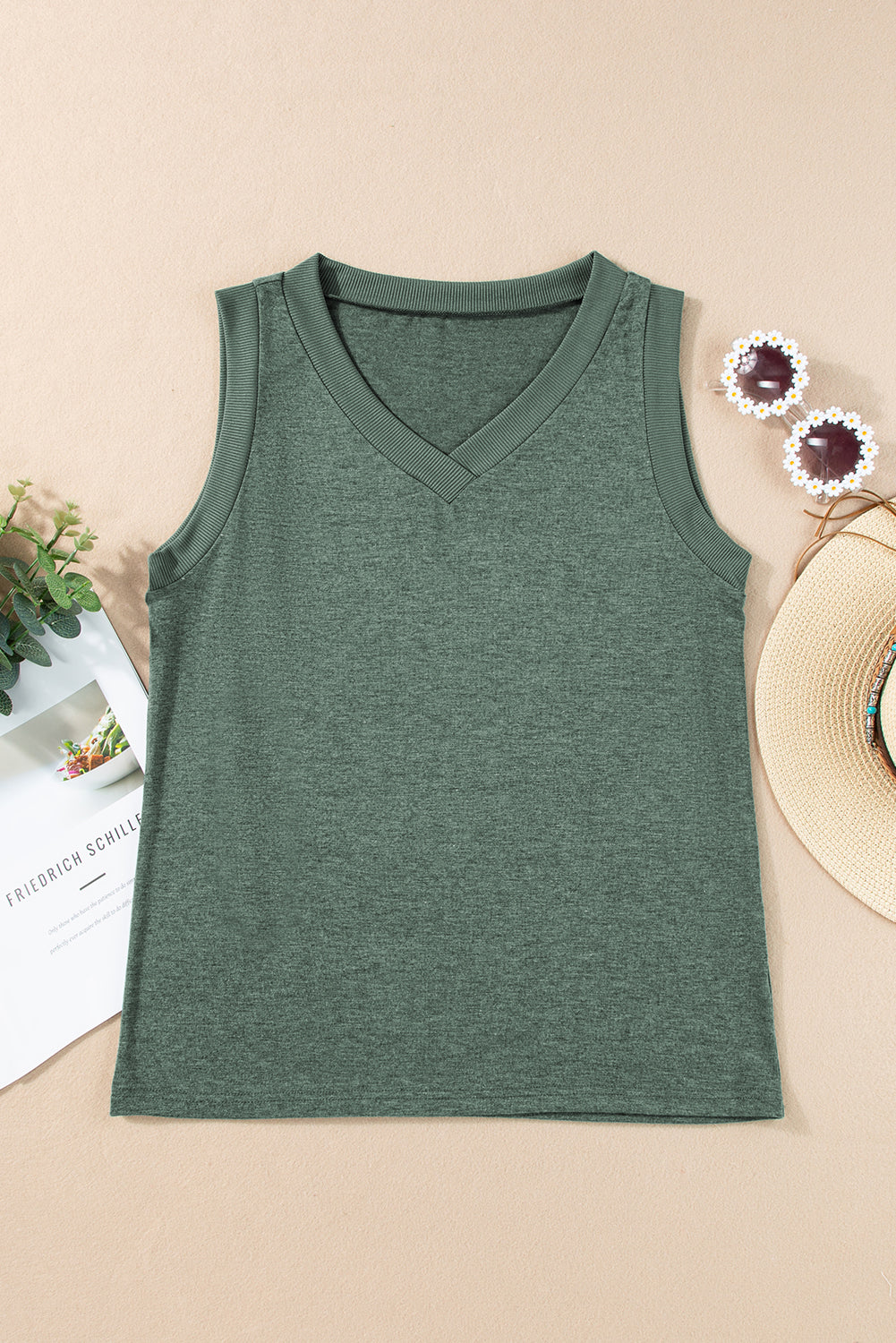 Green tank top on a beige surface with decorative elements