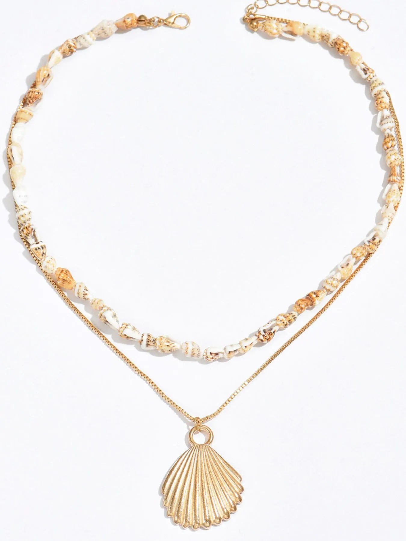 Gold necklace with shell pendant and beaded chain on a white background