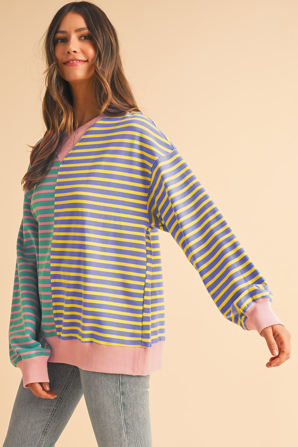 Woman wearing a colorful striped sweater on a beige background