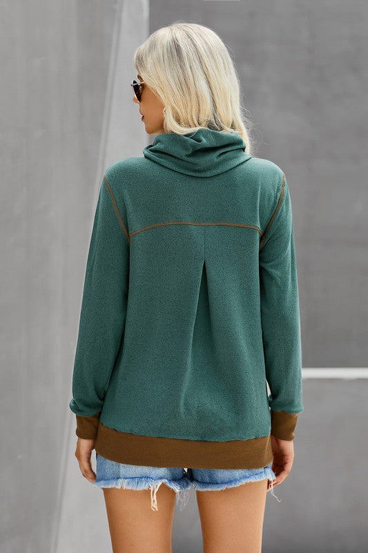 Person wearing a green hoodie with brown accents against a gray background