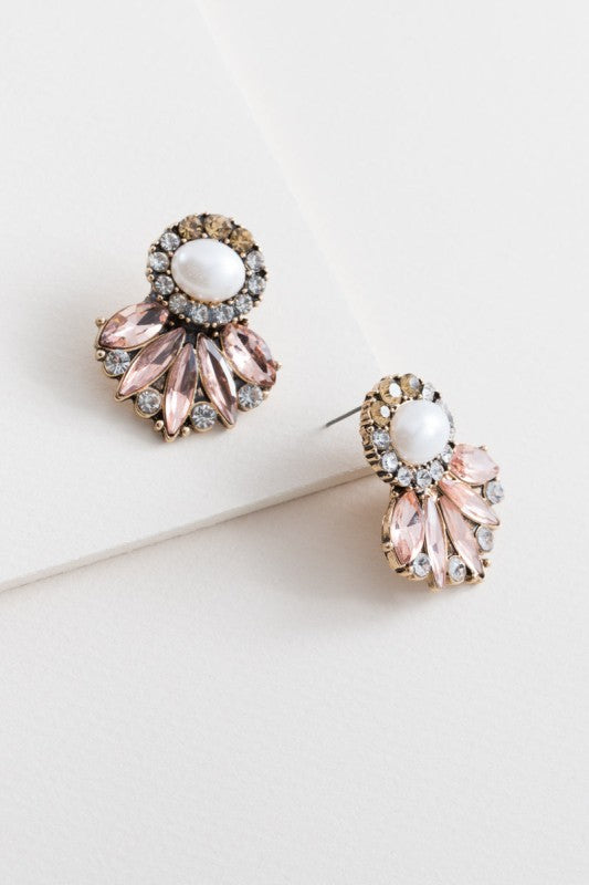Pair of ornate earrings with pink and gold details on a white surface