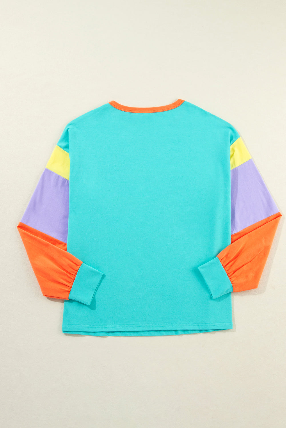 Colorful long-sleeve shirt with a geometric pattern on a beige background