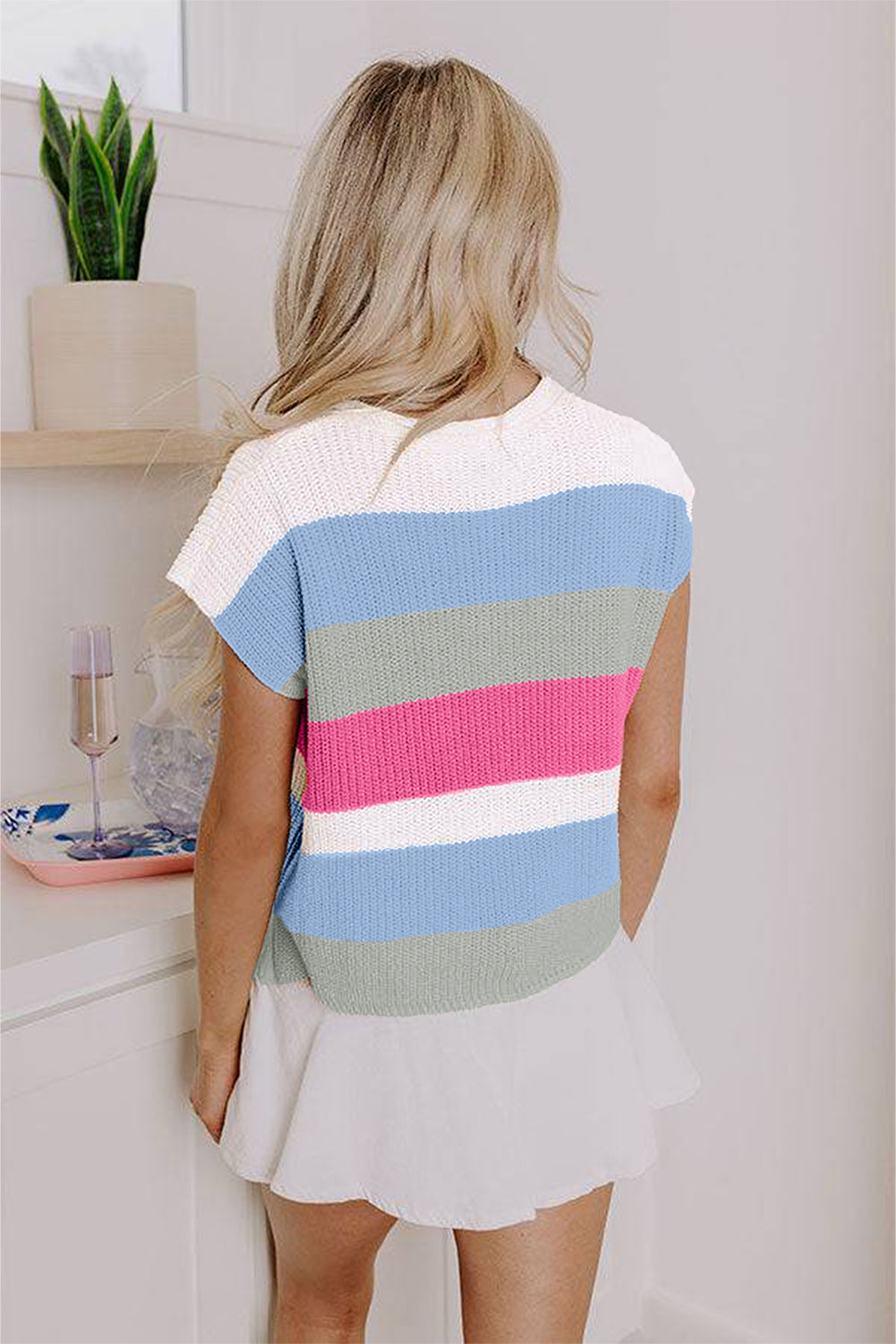 Person wearing a colorful striped shirt in a kitchen setting