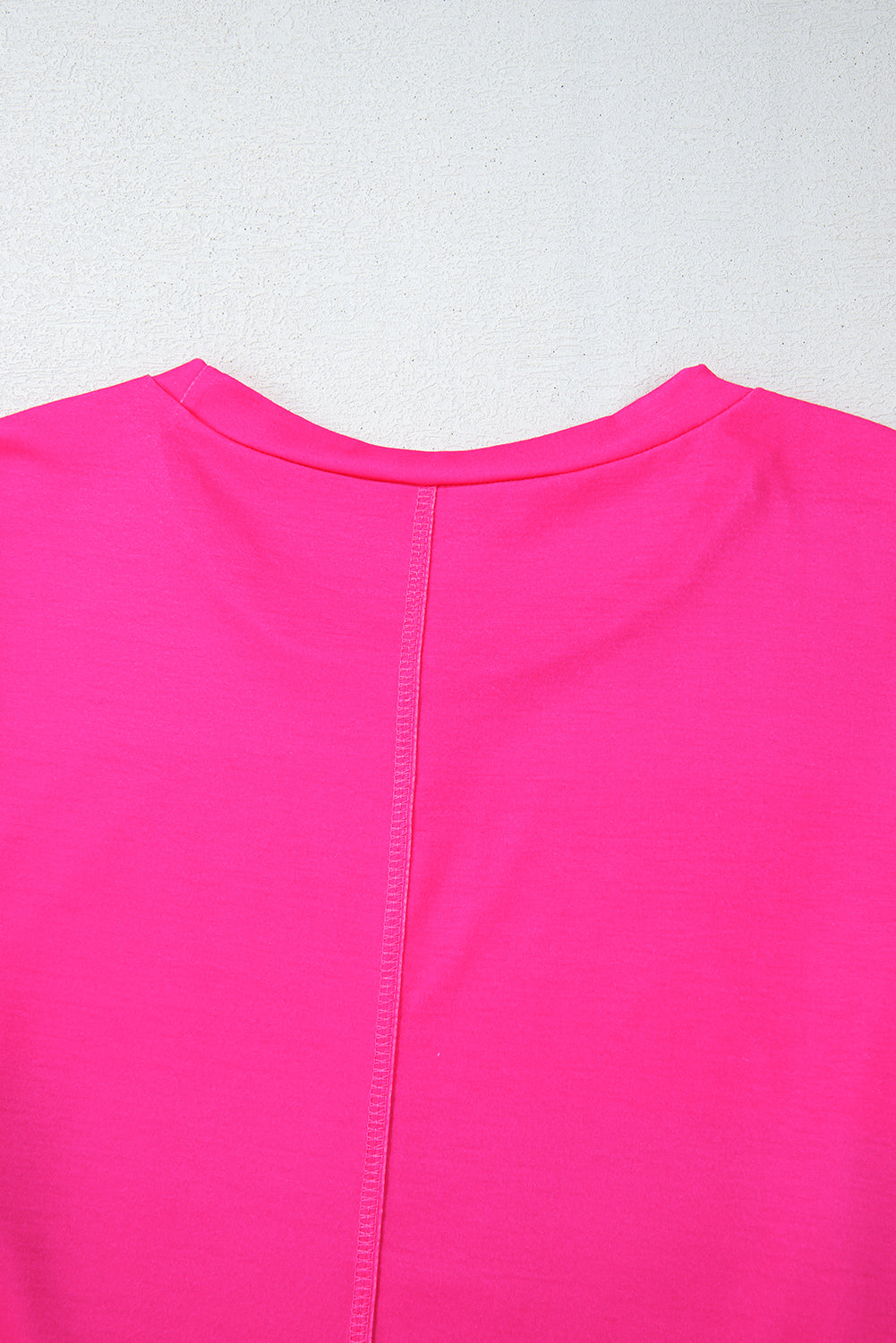 Close-up of a bright pink garment on a light gray background