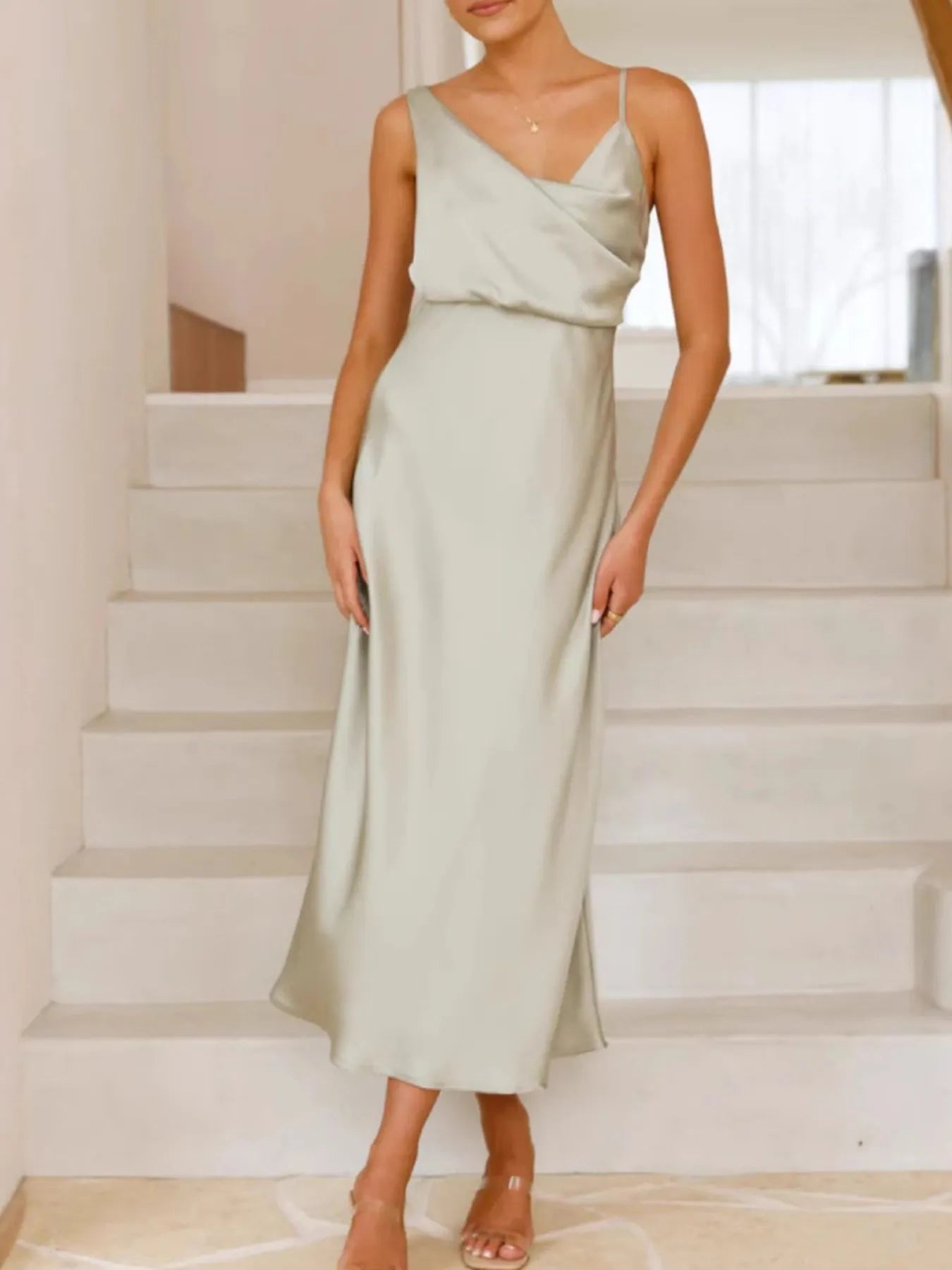 Woman wearing a light green dress standing on a staircase.