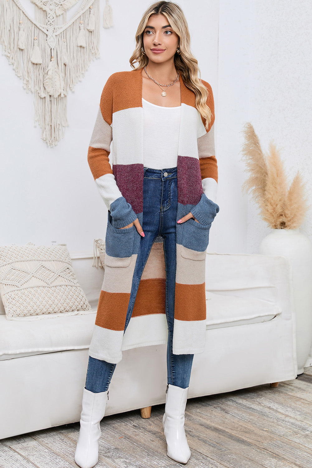 Woman wearing a colorful striped sweater and jeans in a living room setting.