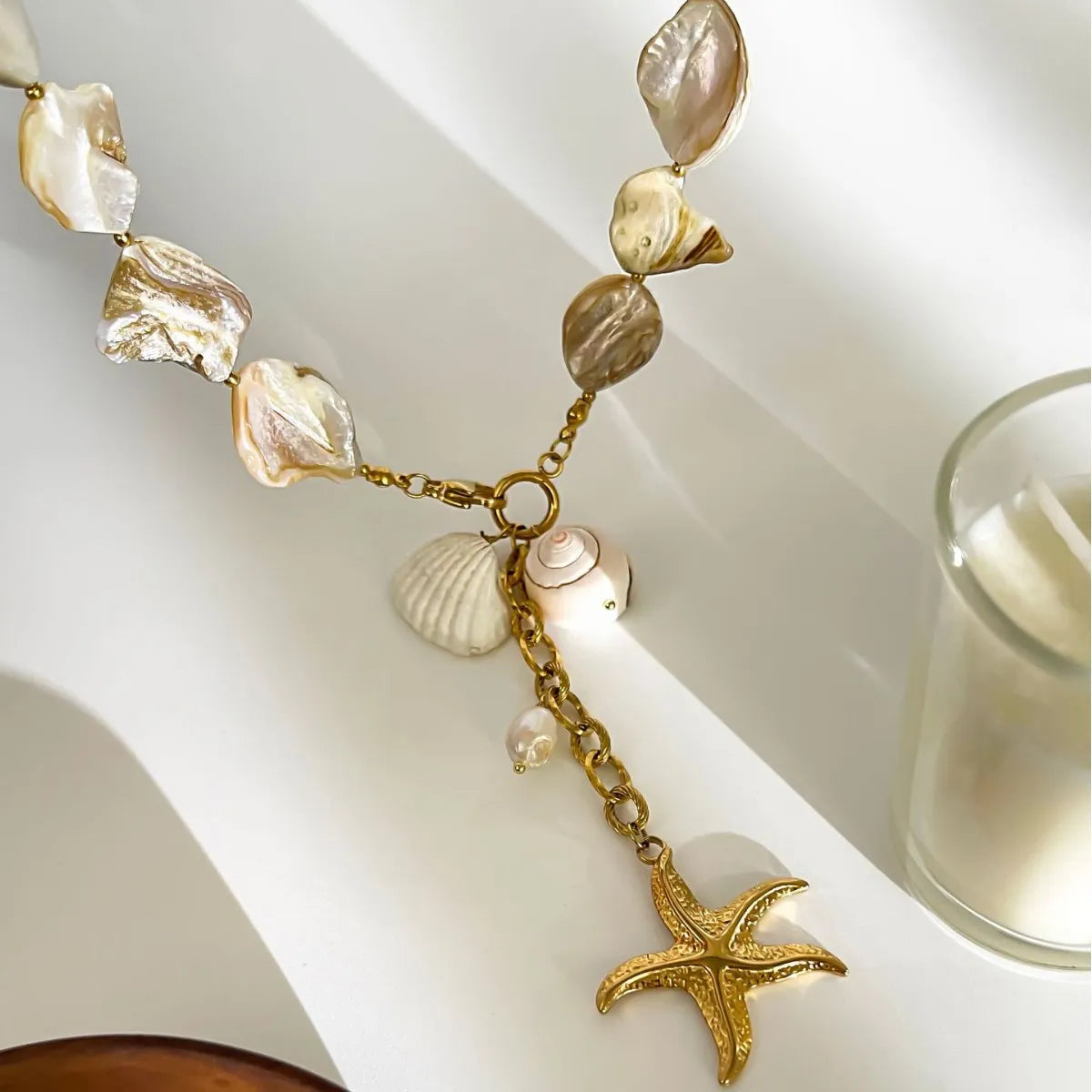Necklace with shell and starfish charms on a white surface