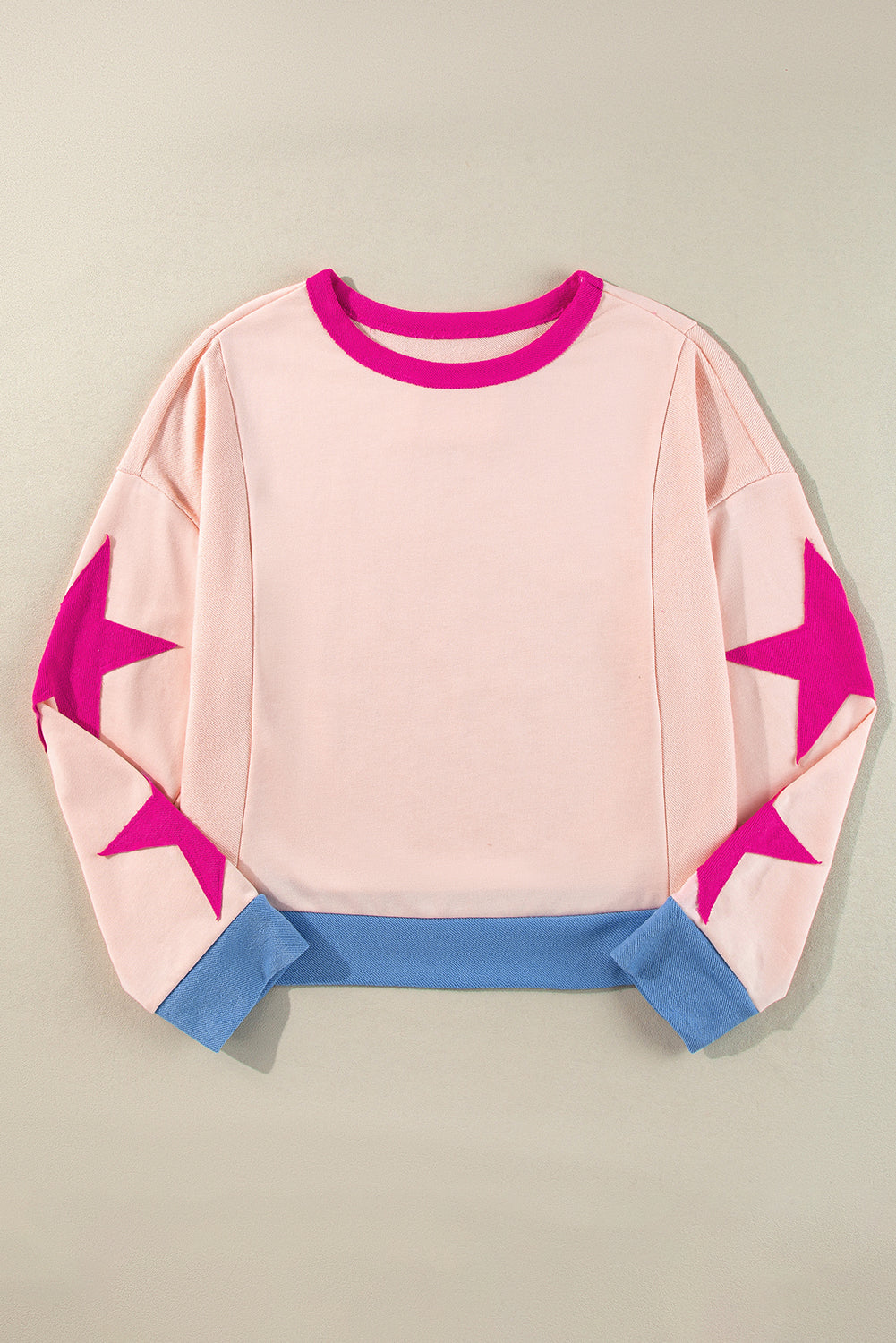 Pink sweater with star designs on a beige background