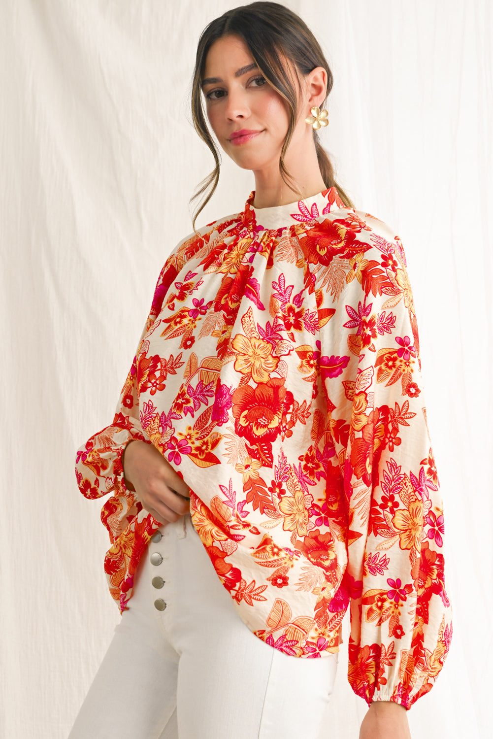 Woman wearing a colorful floral blouse with a plain background