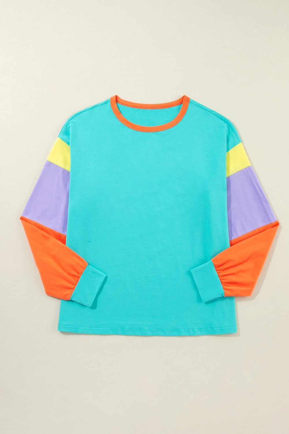 Colorful long-sleeve shirt with a geometric pattern on a beige background
