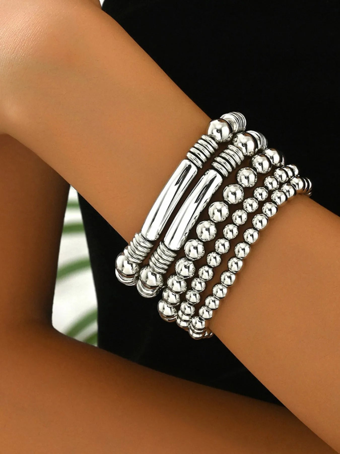 Silver beaded bracelet on a wrist with a blurred background
