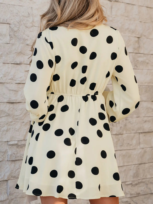 Woman wearing a polka dot dress against a stone wall background